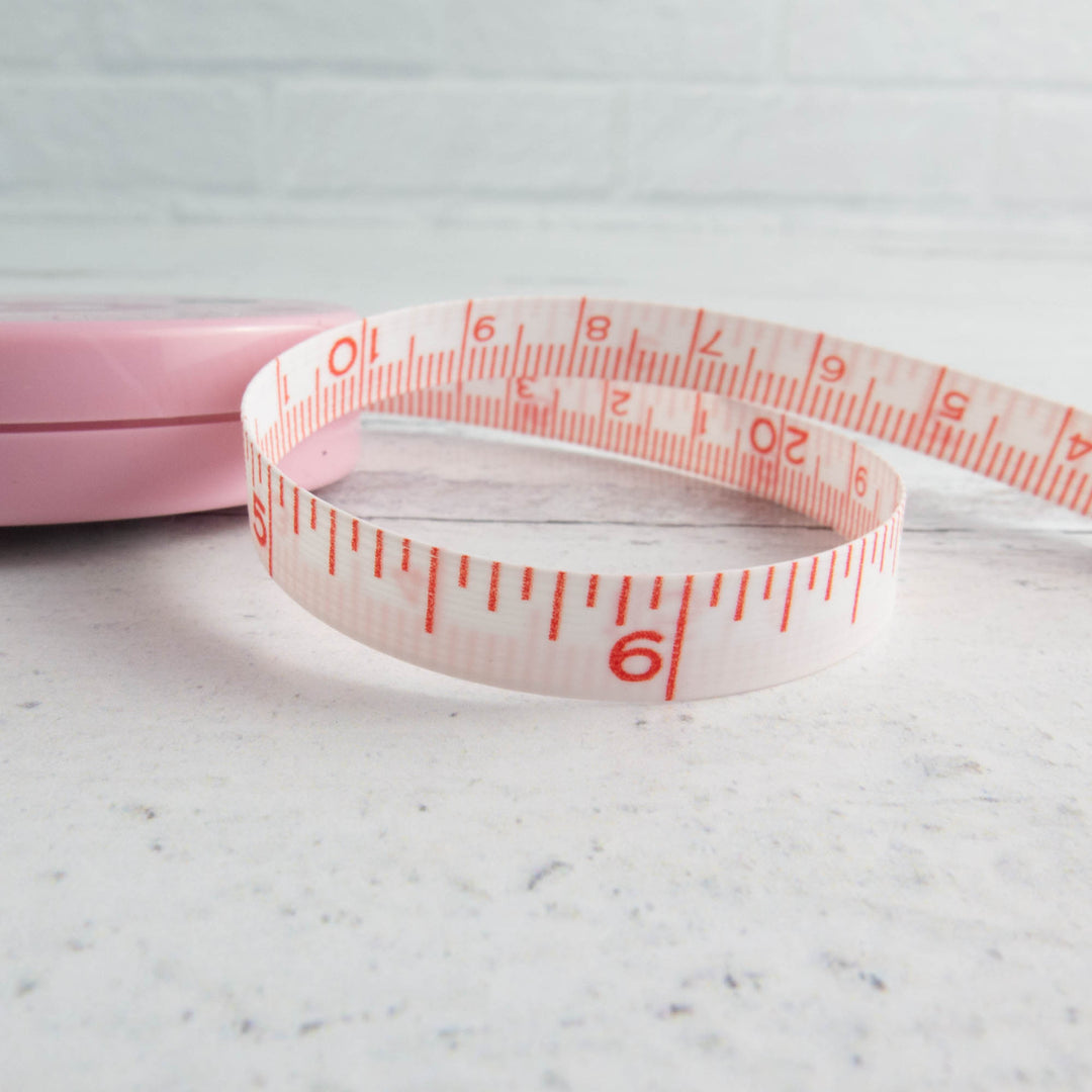Premium Photo  Measuring tape with centimeters and inches on pink  background.